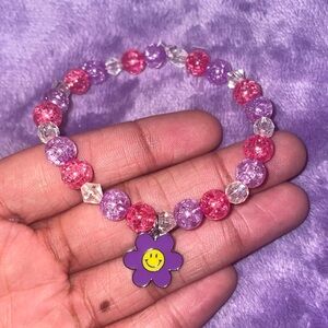 Acrylic beads , pink , purple and clear . With a flower pendent on it as well.